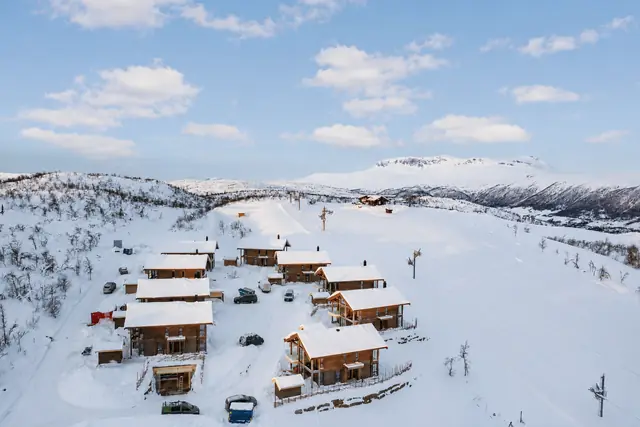 Aerial view of the chalet and the slope in winter